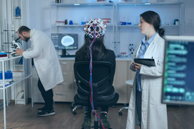 Des scientifiques dans un laboratoire, en présence d'un participant relié à un appareil d'EEG